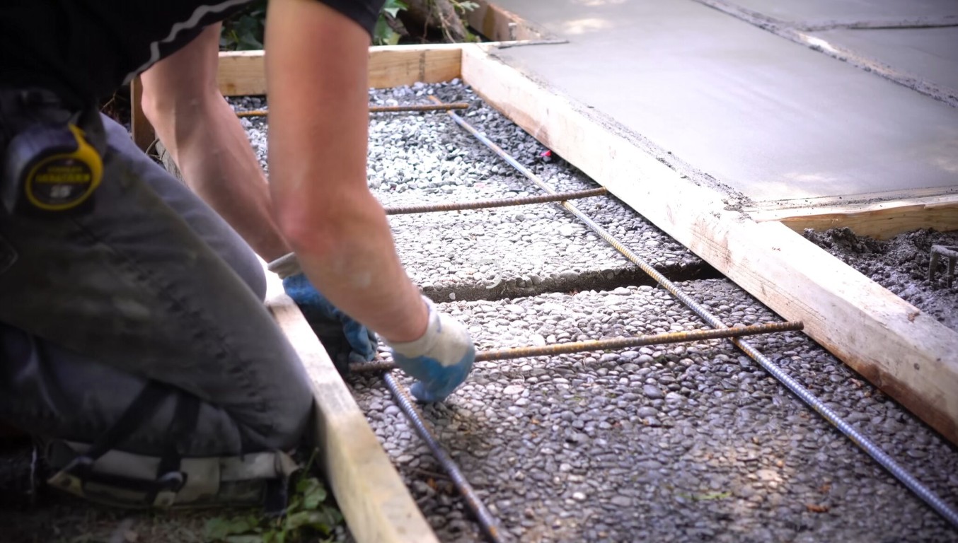 Worker placing rebar and prepping formwork for a commercial concrete foundation in Tacoma, WA